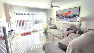 En moderne stue med sofa, sofabord og et billede på væggen.