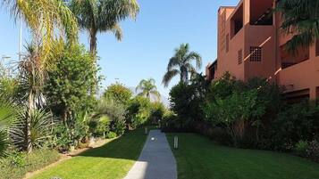 Un chemin menant à un bâtiment doté d’un toit plat et d’un balcon.