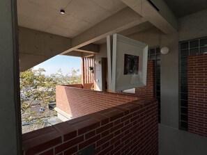 Una habitación con pared de ladrillo, ventana y puerta.