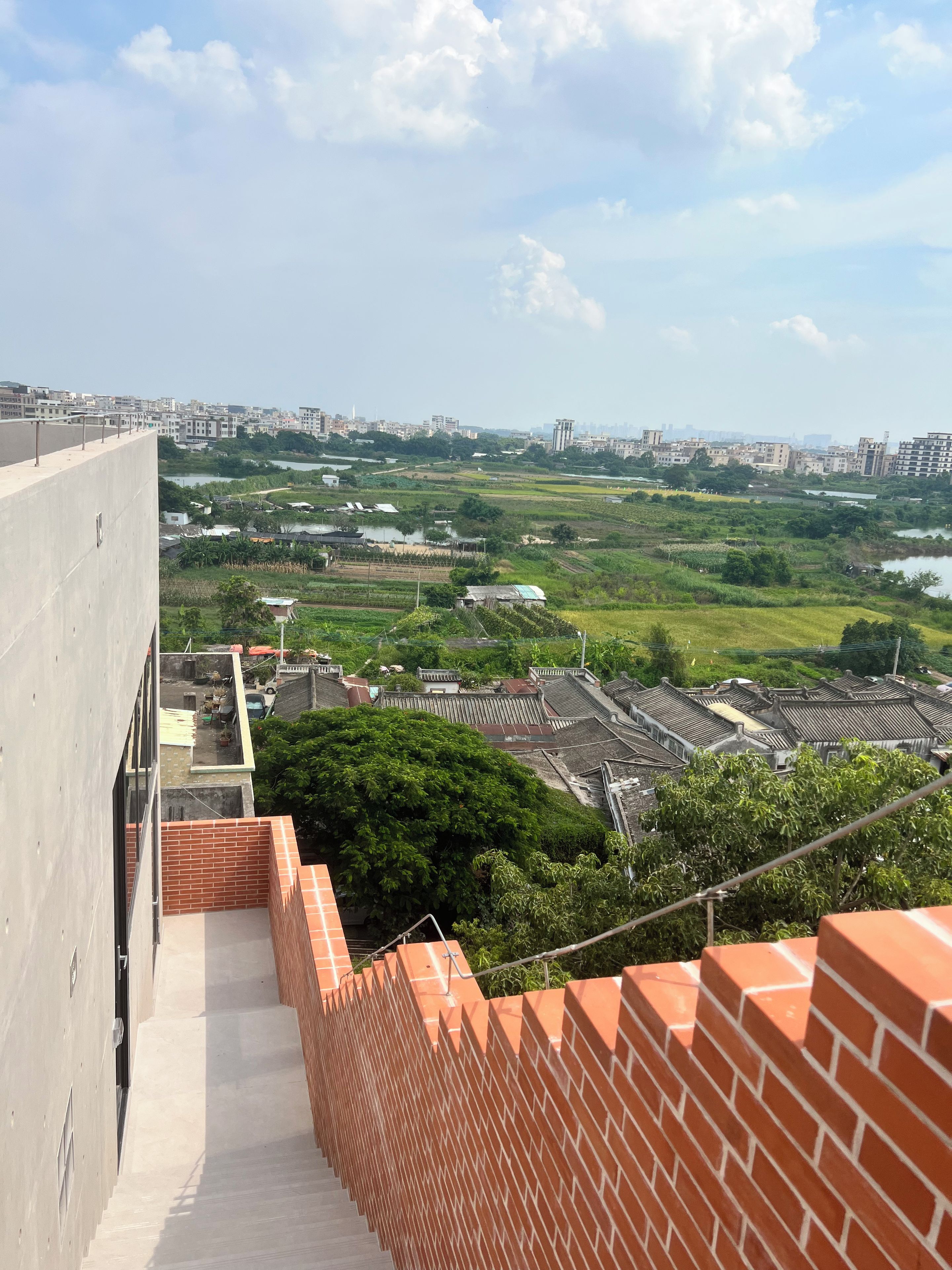 Un edificio alto con vistas a un paisaje urbano y zonas verdes.