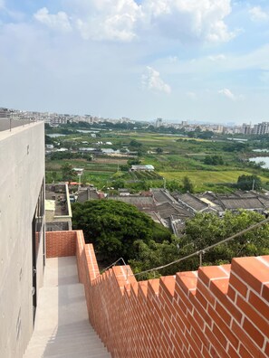 Un edificio alto con vistas a un paisaje urbano y zonas verdes.