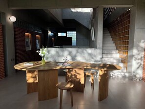 Una cocina moderna con una isla central, una escalera y una pared de ladrillo.