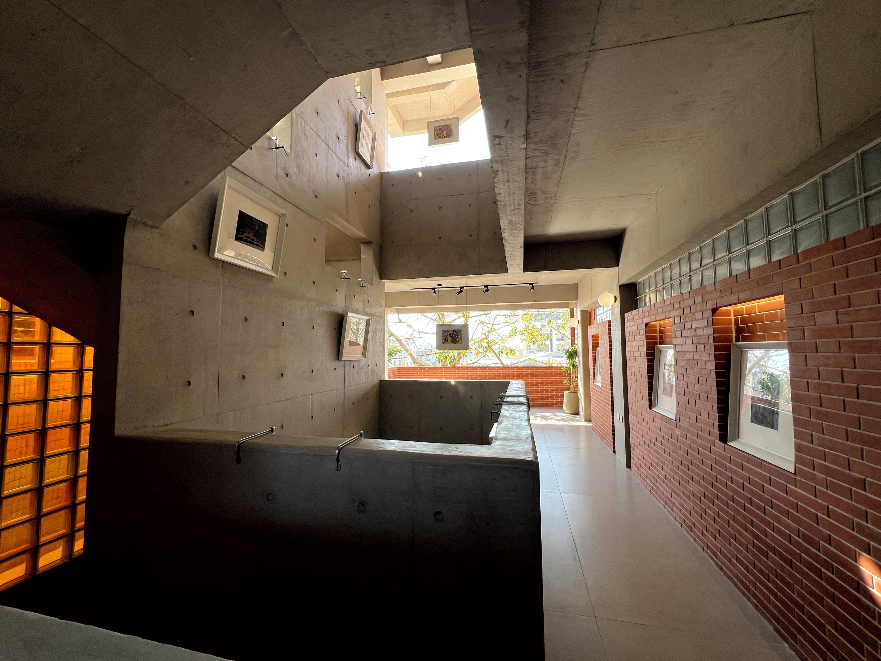 Un interior moderno con paredes de concreto, un banco largo y una pared de ladrillo decorativa.