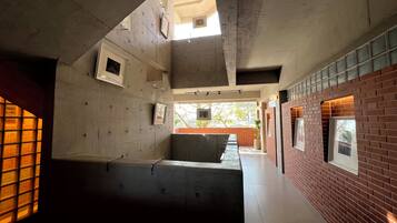 Un interior moderno con paredes de concreto, un banco largo y una pared de ladrillo decorativa.