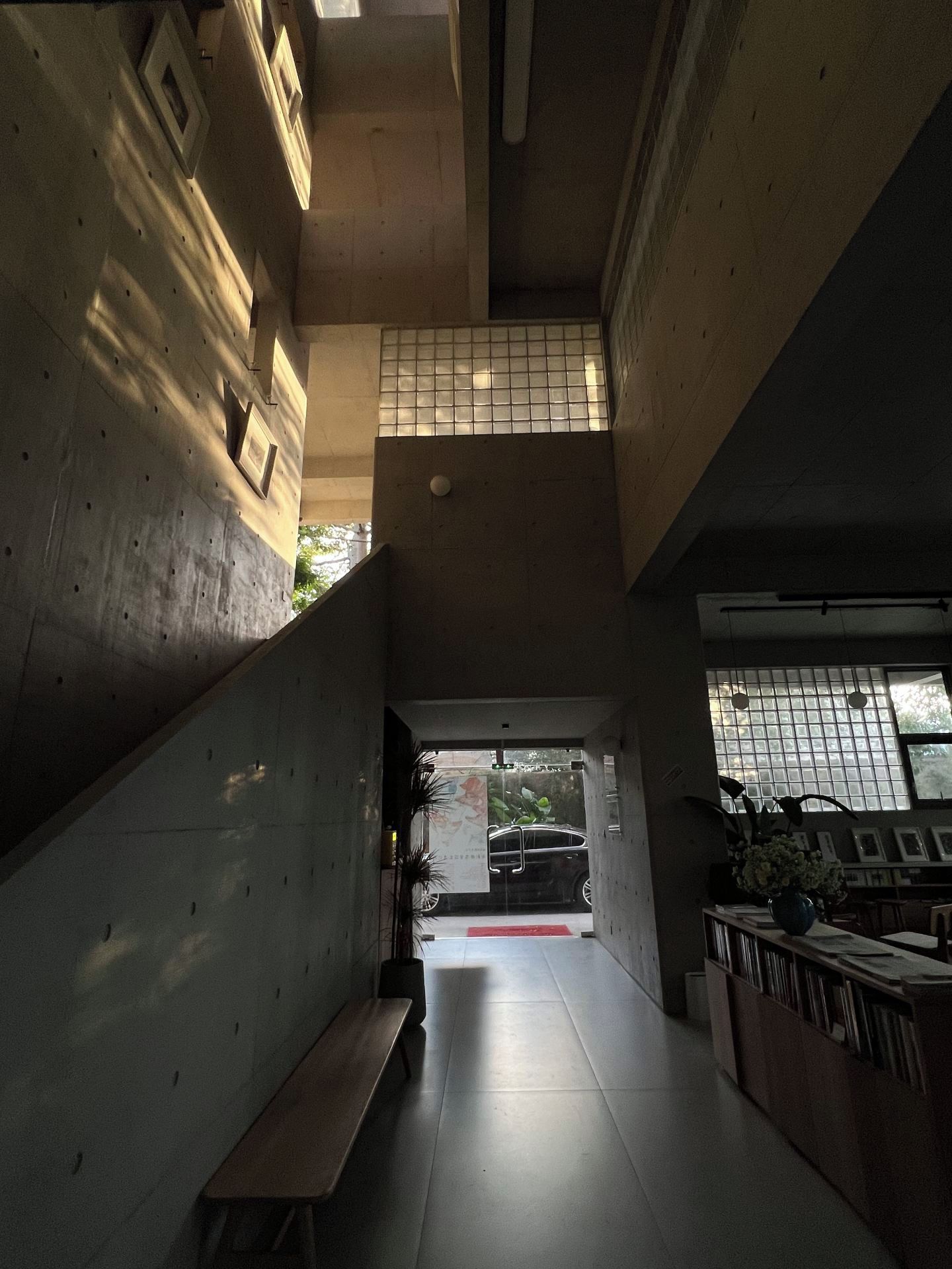 A corridor with a bench, tiled walls, and a door leading outside.