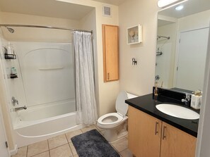 A bathroom with a bathtub, toilet, and sink. - Cozy 1-bedroom apartment in the heart of uptown Oakland with AC and gym access (Oakland)