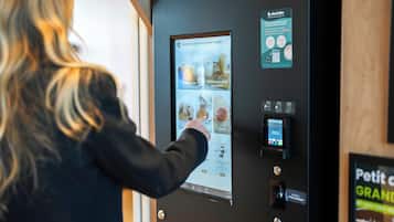 A person interacting with a touchscreen menu in a room with a wooden door and a wall-mounted sign.