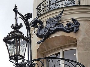 A wrought iron balcony railing with a decorative metal lamp post. - Elegant Saint-Germain Apartment with Refined Parisian Interiors (Paris)