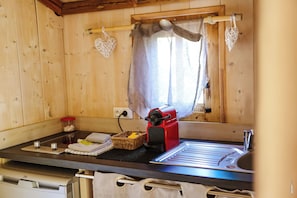 A kitchenette with a red coffee maker, a sink, and a window with curtains. - The Adelaide Lodge - Nature & Tranquility (Cahuzac-sur-Vère)
