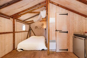A small, wooden cabin-style room with a bed, a heater, and a kitchenette. - The Adelaide Lodge - Nature & Tranquility (Cahuzac-sur-Vère)