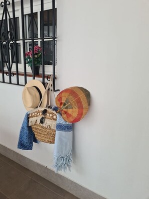 A wall-mounted hat rack with a woven basket and a denim jacket. - 2 bedrooms | Large patio | 2-meter walk to the beach | Huelin (Málaga)