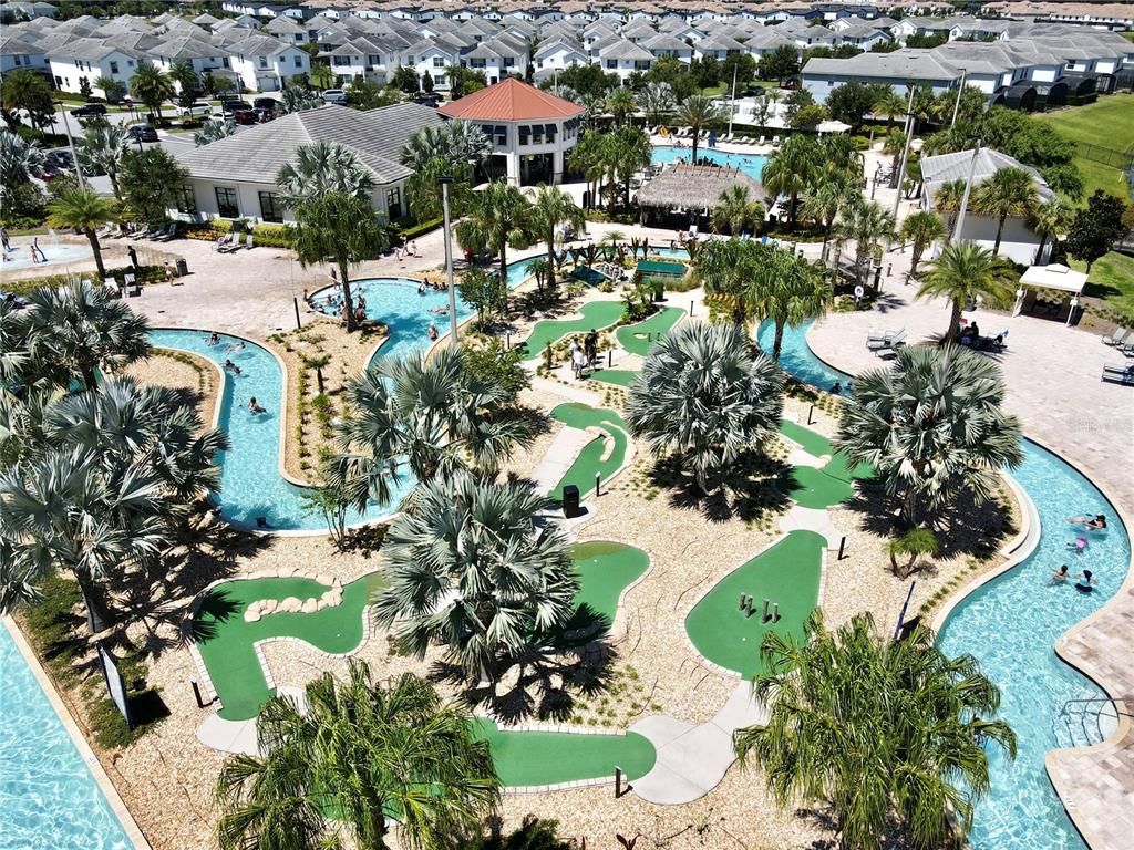 Ein Resort mit mehreren Schwimmbecken, Palmen und einem Golfplatz.