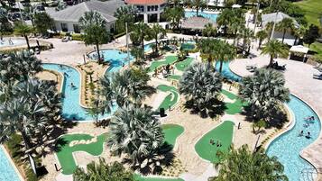 Ein Resort mit mehreren Schwimmbecken, Palmen und einem Golfplatz.