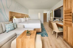 Ein modernes Hotelzimmer mit einem großen Bett, einer Sitzecke, einem Holztisch, einem Fernseher und einem Schreibtisch mit Stuhl.