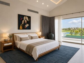 A modern bedroom with a large bed, a nightstand, a vase, and a painting on the wall. - Villa La Mar | Golf & Ocean Views, Private Pool (Punta Cana)