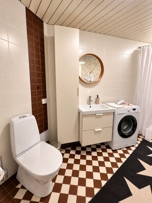 Ein Badezimmer mit Toilette, Waschmaschine und Waschbecken.