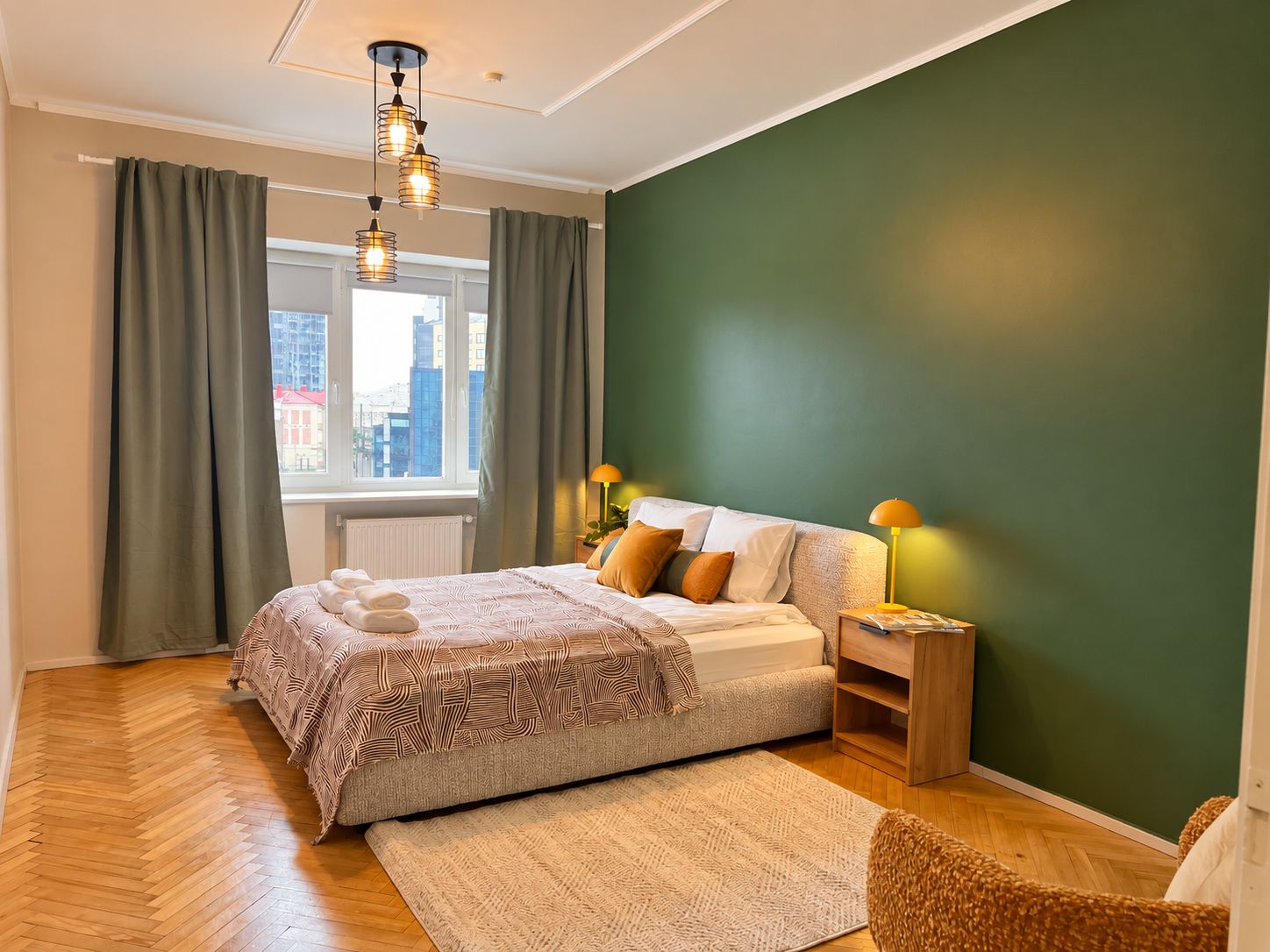A modern bedroom with a bed, bedside lamps, a window with curtains, and a view of buildings.
