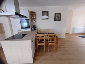Una cucina moderna con zona pranzo, sedie di legno e tavolo.
