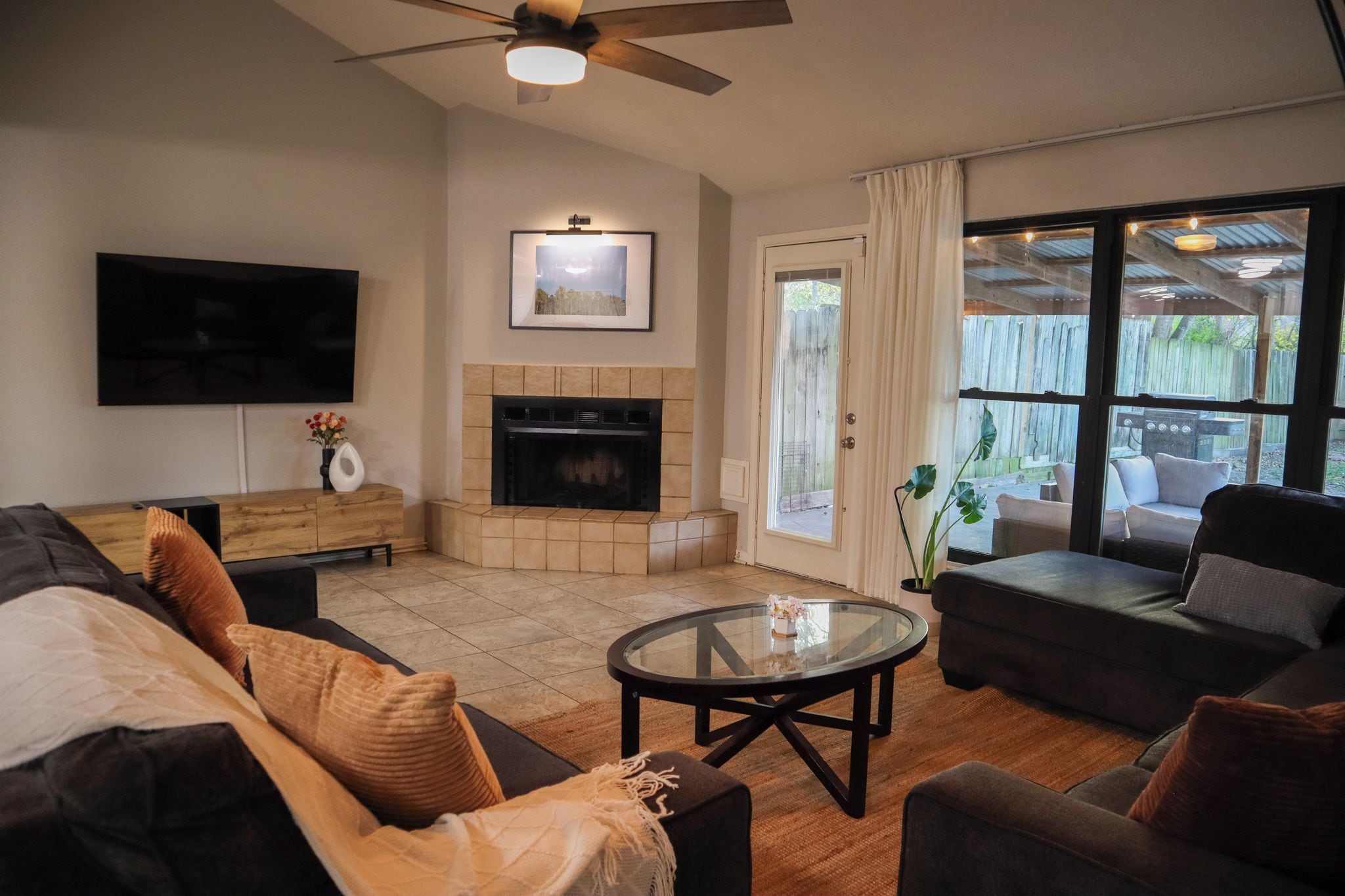 A living room with a fireplace, a television, and a large window.