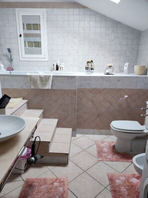 A bathroom with a bathtub, toilet, sink, and a shower area. - MAISON PLATONE PRESTIGE (Alessandria)