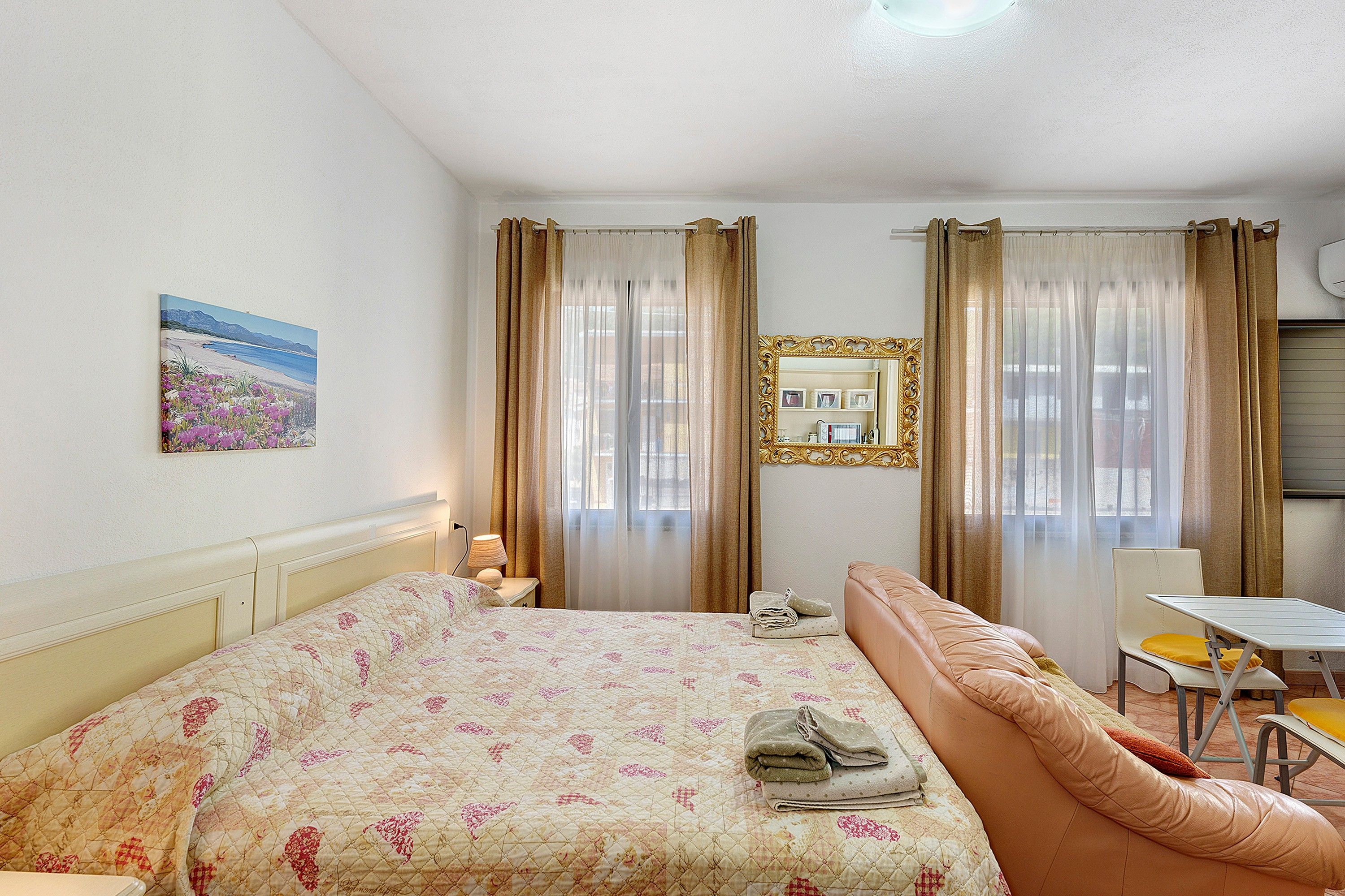Une chambre d’hôtel avec un lit, un canapé, une table et une chaise.