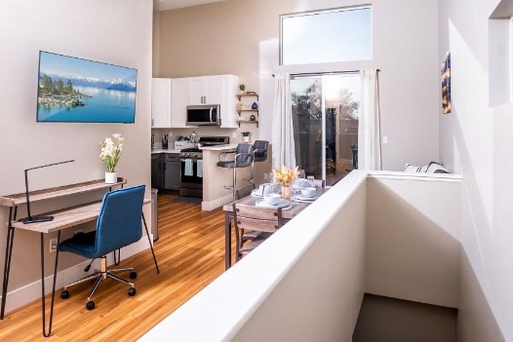 Eine moderne Wohnung mit Küche, Essbereich und einem Balkon mit Blick.