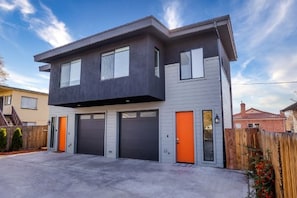 A modern two-story house with a garage, a wooden fence, and a clear sky. - Hybrid King Bed•Pets Ok•Walkers Paradise•500mbps (Reno)