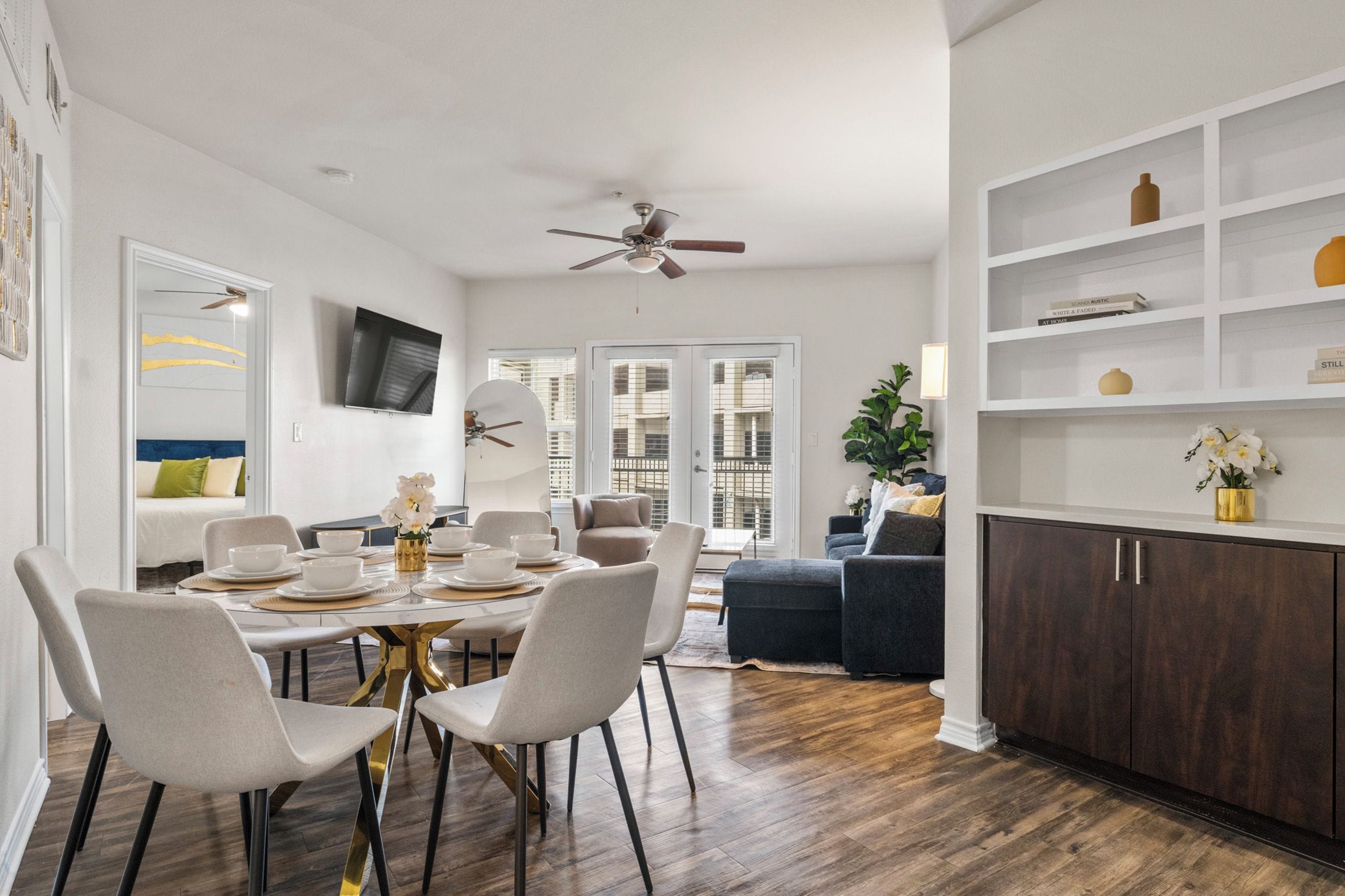 Un espace repas moderne avec une table ronde, des chaises et un ventilateur de plafond.