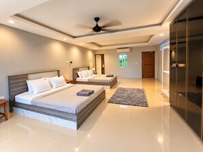 A modern bedroom with two beds, a ceiling fan, and a large sliding door. - 4 bedroom & bathroom pool villa, with golf view. Only 7km to Patong (Tambon Kathu)