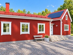 A red house with a white window frame, a bench, and a solar panel on the roof. - Unique event venue—pool, gym, and sauna (Stockholm)