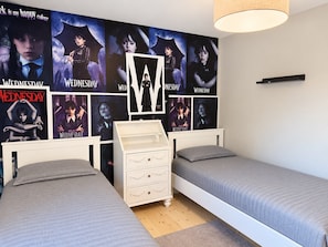 A bedroom with two beds, a dresser, and a wall decorated with posters. - Unique event venue—pool, gym, and sauna (Stockholm)