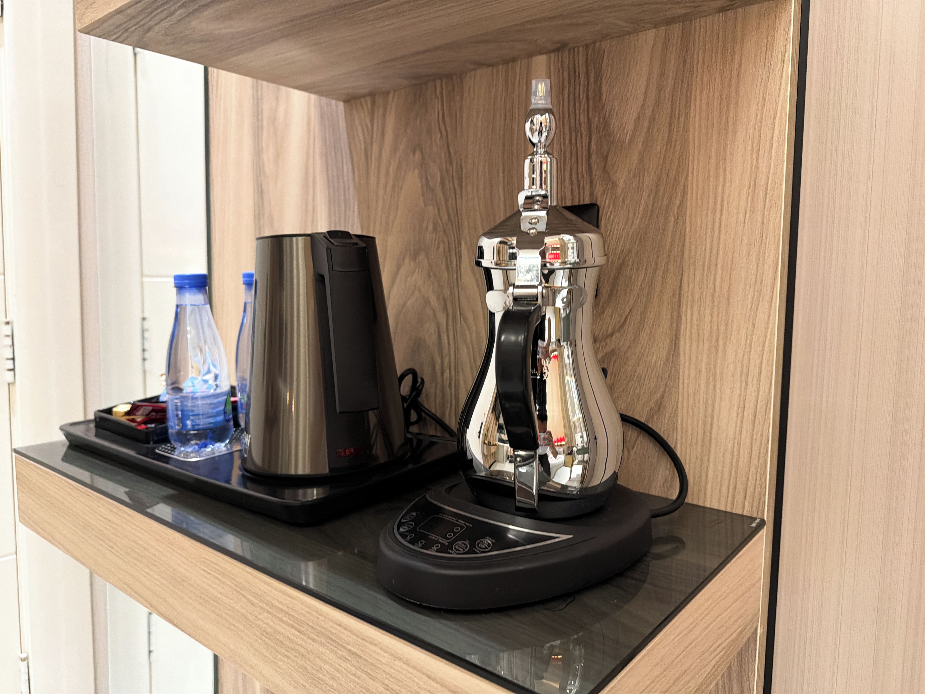 Eine Kaffeemaschine und eine Wasserflasche auf einer Arbeitsplatte.