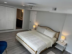 A bedroom with a bed, bedside tables, a chair, and a wardrobe. - Mia's House (Radcliff)