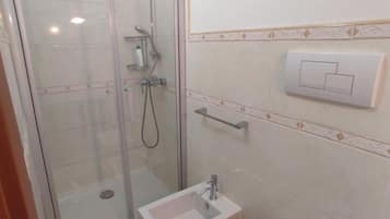 Un bagno con doccia vetrata, lavandino e water.