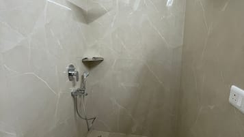 Un baño con ducha, inodoro y un perchero para toallas.