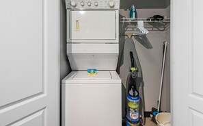 A laundry area with a washing machine, a dryer, and a cleaning tool. - Upscale 1 bed, in-unit W/D in Central White Plains (White Plains)