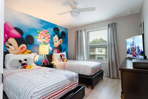 A hotel room with two beds, a large Mickey Mouse mural, a television, and a ceiling fan. - 4BR near Disney | Private pool, themed rooms (Kissimmee)