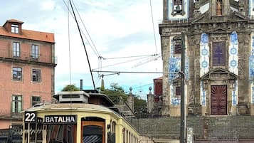 Eine historische Straßenbahn mit der Nummer 22 und dem Schriftzug 'BATALHA' an der Seite, geparkt auf Gleisen vor einem historischen Gebäude.