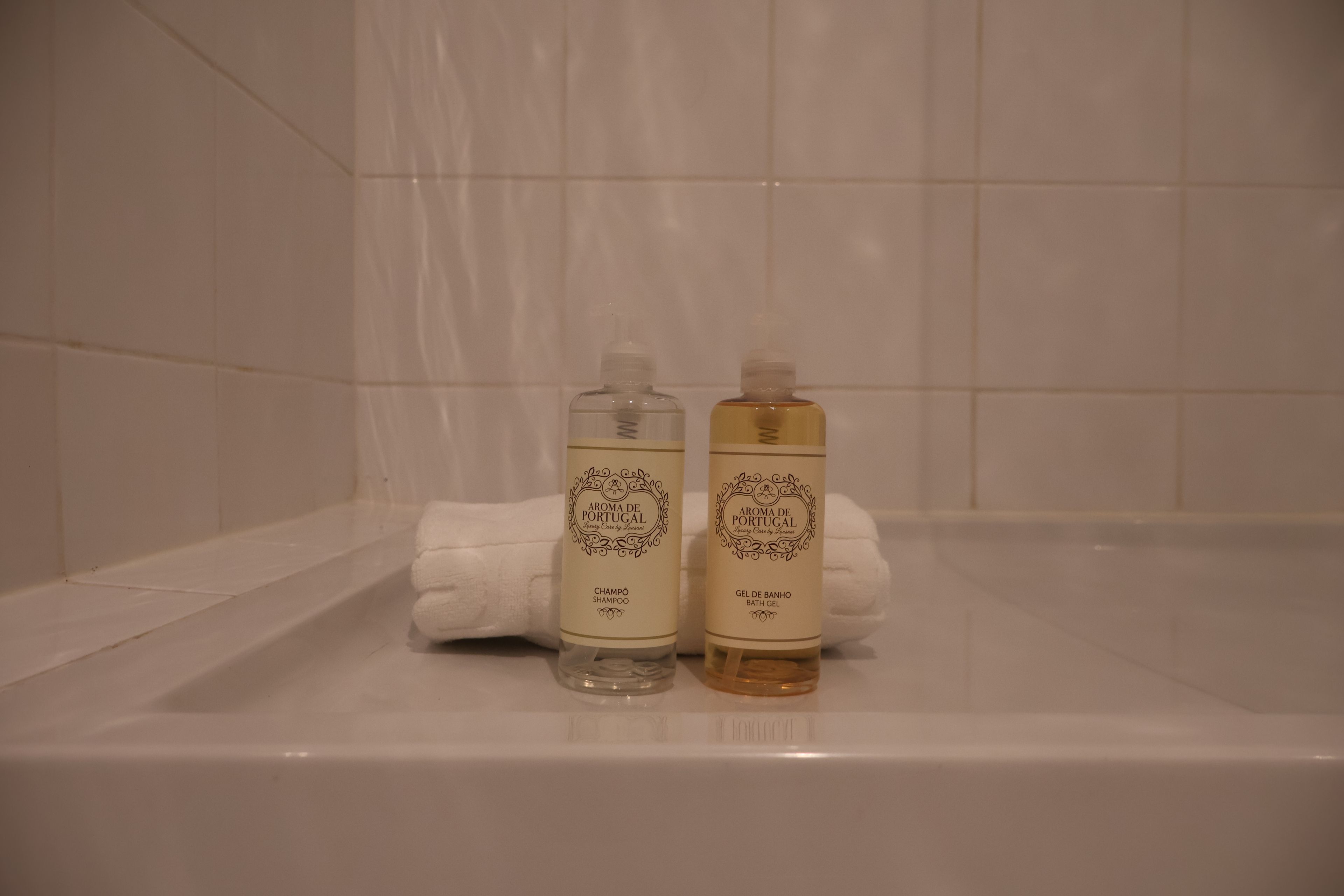 Zwei Toilettenartikel in einer Badewanne mit einem weißen Handtuch.