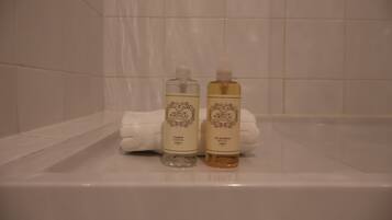 Zwei Toilettenartikel in einer Badewanne mit einem weißen Handtuch.
