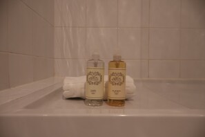 Zwei Toilettenartikel in einer Badewanne mit einem weißen Handtuch.