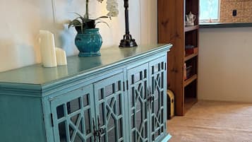 Un mueble color turquesa con puertas de cristal y una pequeña rejilla en la parte inferior.