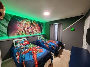Ein Schlafzimmer mit zwei Betten, einem großen Wandgemälde und einem Fernseher.