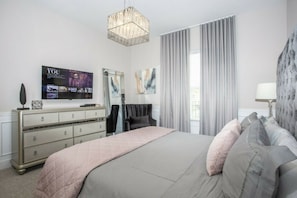 A bedroom with a bed, dresser, TV, and curtains. - 5BR Harry Potter townhouse | 15 min to Disney (Kissimmee)