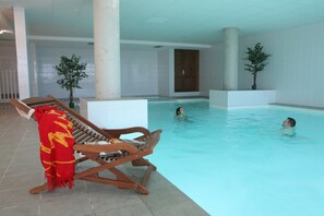 An indoor swimming pool with lounge chairs and a red blanket. - Font-Romeu | Piscine sur place | Balcon (Font-Romeu)