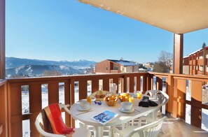 A balcony with a table set for breakfast, overlooking a snowy mountain landscape. - Font-Romeu | Piscine sur place | Balcon (Font-Romeu)