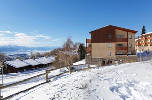 A multi-story hotel with a ski slope in the foreground.