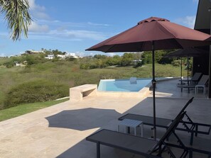 A pool area with a hot tub, lounge chairs, and a patio umbrella. - Hillside sanctuary with pool & sunset sea views. (Los Chivos)