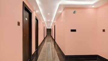 A corridor with doors on both sides, a sign indicating an office, and a tiled floor.