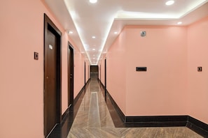 A corridor with doors on both sides, a sign indicating an office, and a tiled floor.